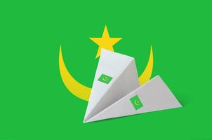 mauritania vlag afgebeeld Aan papier origami vliegtuig. handgemaakt kunsten concept foto