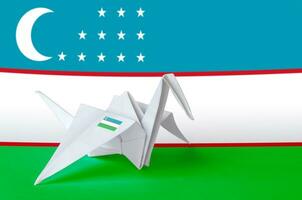 Oezbekistan vlag afgebeeld Aan papier origami kraan vleugel. handgemaakt kunsten concept foto
