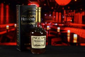 Charkov, Oekraïne - februari 14, 2021 hennessy heel speciaal cognac fles Aan houten tafel met rood bar interieur Aan achtergrond. de elite alcohol foto