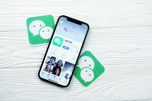 Charkov, Oekraïne - maart 5, 2021 wechat boodschapper icoon en toepassing van app op te slaan Aan iphone 12 pro Scherm scherm Aan wit tafel foto