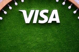 Visa logo Aan groen gras in fotozone met veel wit lichtlamp bollen advertentie houten plank foto
