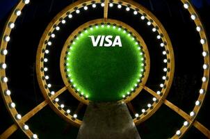 Visa logo Aan groen gras in fotozone met veel wit lichtlamp bollen advertentie houten plank foto