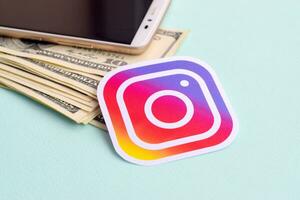 instagram papier logo leugens met envelop vol van dollar rekeningen en smartphone foto