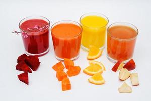 glazen glazen met sap en stukjes groenten en fruit foto