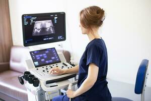 dokter vrouw aan het doen echografie scannen diagnostisch van schildklier klier zittend in kantoor in kliniek. foto