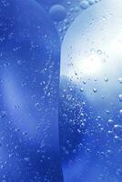 olie bubbels dichtbij omhoog. cirkels van water macro. abstract licht blauw achtergrond foto