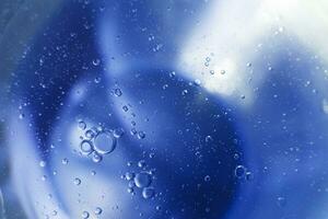 olie bubbels dichtbij omhoog. cirkels van water macro. abstract licht blauw achtergrond foto