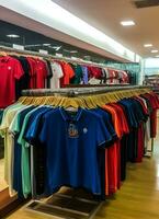 rij van modieus polo t-shirts voor Mens Aan houten hanger of rek in een kleding winkel kleinhandel winkel concept door ai gegenereerd foto