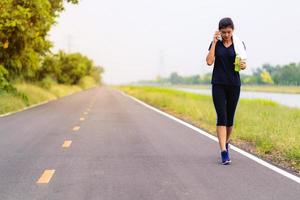 sport meisje, vrouw die op de weg loopt, gezonde fitness vrouw training foto