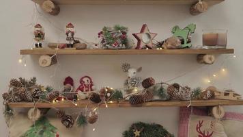 een kamer met kerstversiering en speelgoed. op de houten planken liggen souvenirs en decoraties
