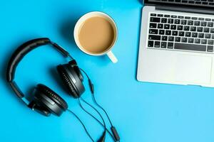 muziek- of podcast achtergrond met elektronisch apparaten, koptelefoon, koffie en laptop Aan kantoor bureau concept door ai gegenereerd foto