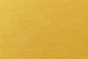 close-up gele of gouden mosterd stof oppervlaktetextuur voor background foto