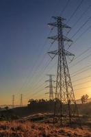 hoogspanningstransmissietoren bij zonsondergang foto