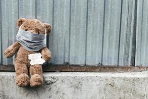 teddybeer in medisch masker met einde van de wereldnota. foto