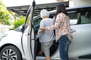 hulp en ondersteuning Aziatische senior vrouw patiënt bereidt zich voor om naar haar auto te gaan. foto