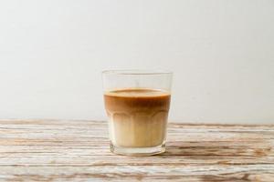 glas latte koffie, koffie met melk op hout achtergrond foto