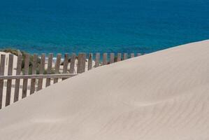 houten hekken Aan uitgestorven strand duinen in tarifa, Spanje foto