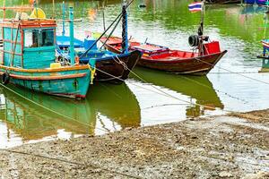 Thaise vlag visvangst boten lijn de rivier- in de bruisend haven, vastleggen de essence van de levendig visvangst industrie in Thailand. foto