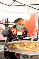 puebla, Mexico 2023 - senior dame bereidt zich voor chalupa's poblana's ondergedompeld in vet, Mexicaans voedsel van de stad van puebla, Mexico foto