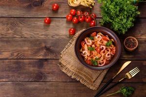 fettuccine pasta met garnalen, cherrytomaatjes, saus, specerijen en kruiden foto