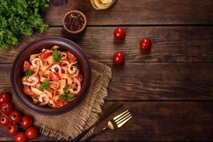 fettuccine pasta met garnalen, cherrytomaatjes, saus, specerijen en kruiden foto