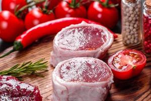 verse rauwe biefstuk mignon, met zout, peperkorrels, tijm, tomaten foto