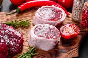 verse rauwe biefstuk mignon, met zout, peperkorrels, tijm, tomaten foto