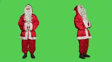 heilige Nick persoon in feestelijk rood pak lachend over- vol lichaam groene scherm, poseren net zo seizoensgebonden hoofd karakter gedurende winter viering. volwassen afbeelden de kerstman claus met wit baard en hoed. foto