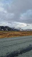 besneeuwd berg keten in winters IJsland, lang weg concept in de buurt ijzig velden en heuvels in nordic hooglanden. enorm langs de weg landschap en IJslands landschappen, fantastisch rotsachtig kliffen in wildernis. foto