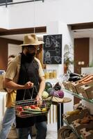 hipster in nul verspilling supermarkt vulling boodschappen doen mand met gezond plaatselijk gegroeid groenten. milieuvriendelijk bewust klant buying biologisch niet ggo voedsel van lokaal buurt winkel foto