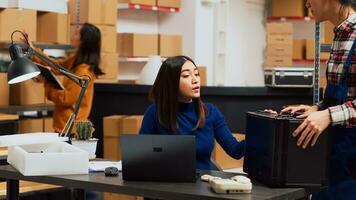 klein bedrijf eigenaar op zoek Bij logistiek Aan laptop, planning opstarten beheer en gebruik makend van voorraad logistiek. jong vrouw werken net zo ondernemer in opslagruimte kamer magazijn. statief schot. foto