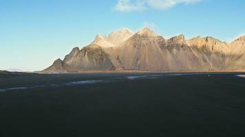 antenne visie van stokksnes zand strand in IJslands landschap, majestueus Vestrahorn bergen in arctisch landschap. spectaculair IJsland panoramisch visie met atlantic oceaan oever, kustlijn. langzaam beweging. foto