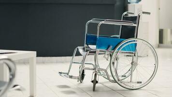 medisch kliniek ontvangst met rolstoel in ziekenhuis registratie lobby, leeg voorkant bureau met afspraak vormen. onbekwaamheid vriendelijk Gezondheid zorg centrum met medisch folders. handheld schot. foto