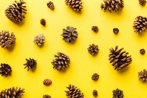 pijnboom kegels Aan gekleurde tafel. natuurlijk vakantie achtergrond met dennenappels gegroepeerd samen. vlak leggen. winter concept foto