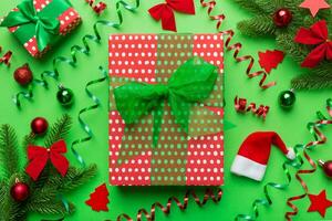 Kerstmis samenstelling. cadeaus doos met nieuw jaar decoraties Aan gekleurde achtergrond. kerstmis, winter, nieuw jaar concept. vlak leggen, top visie, kopiëren ruimte foto
