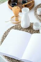 boek mockup ontwerp. blanco wit boek Aan dining tafel in Aziatisch stijl met serviesgoed foto