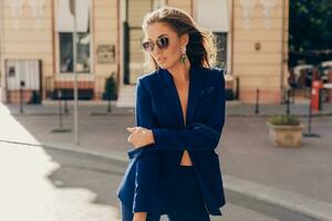 elegant aantrekkelijk vrouw vervelend blauw elegant pak wandelen in straat foto