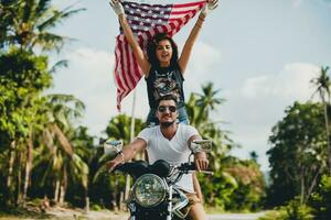 jong paar in liefde, rijden een motorfiets, knuffel, passie, vrij geest, Amerikaans vlag foto