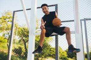 zwart Mens aan het doen sport, spelen basketbal Aan zonsopkomst, actief levensstijl, zonnig zomer ochtend- foto