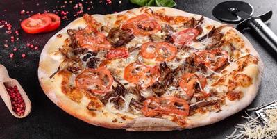 verse warme pizza met vlees, champignons, kaas en tomaten foto