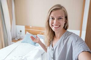 gelukkig vrouw tonen haar hotel kamer nemen selfie foto