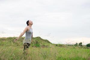 jonge mooie vrouw die handen met vreugde en inspiratie uitspreidt bij weiden foto