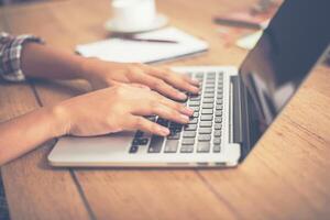 close-up vrouw handen typen op laptop in kantoor. foto