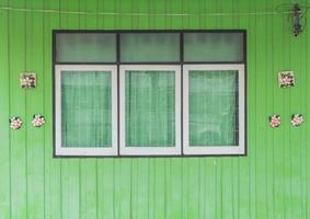 oud venster op groene houten muur foto