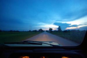 recht op de weg kijken vanuit de auto die op de route naar huis rijdt foto