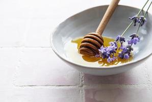 kom met honing en verse lavendelbloemen foto
