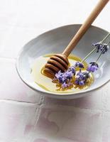 kom met honing en verse lavendelbloemen foto