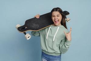 positief, ondeugend meisje met een schaats op haar schouder foto
