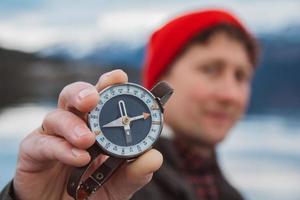 reiziger man houdt een oud kompas tegen foto