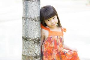 klein meisje aziatisch van een glimlachende staande in het park foto